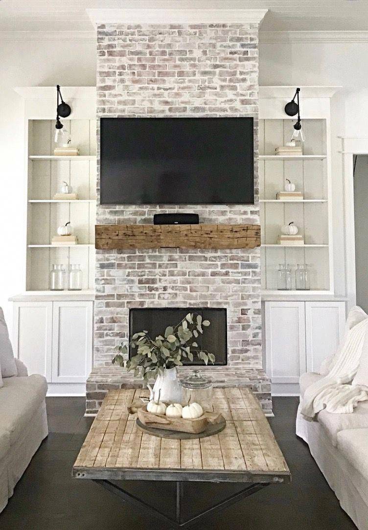 whitewashed fireplace in living room with tv mounted over mantel