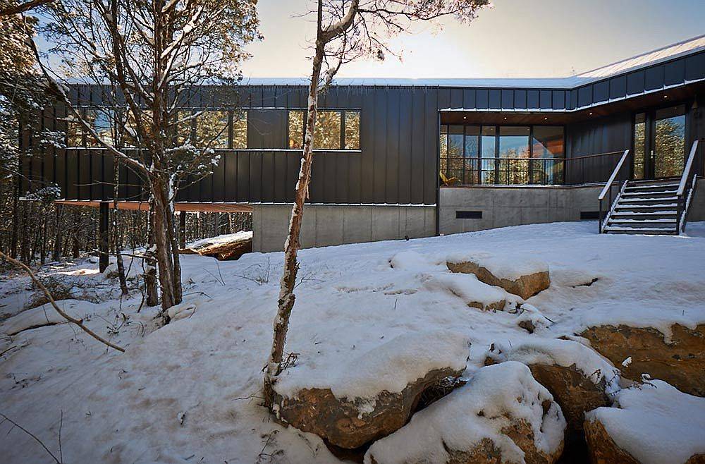 Cantilevered structure of the home hovers above the rocky landscape