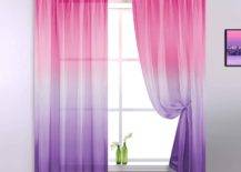Green bottles with flowers on window having pink and purple curtain