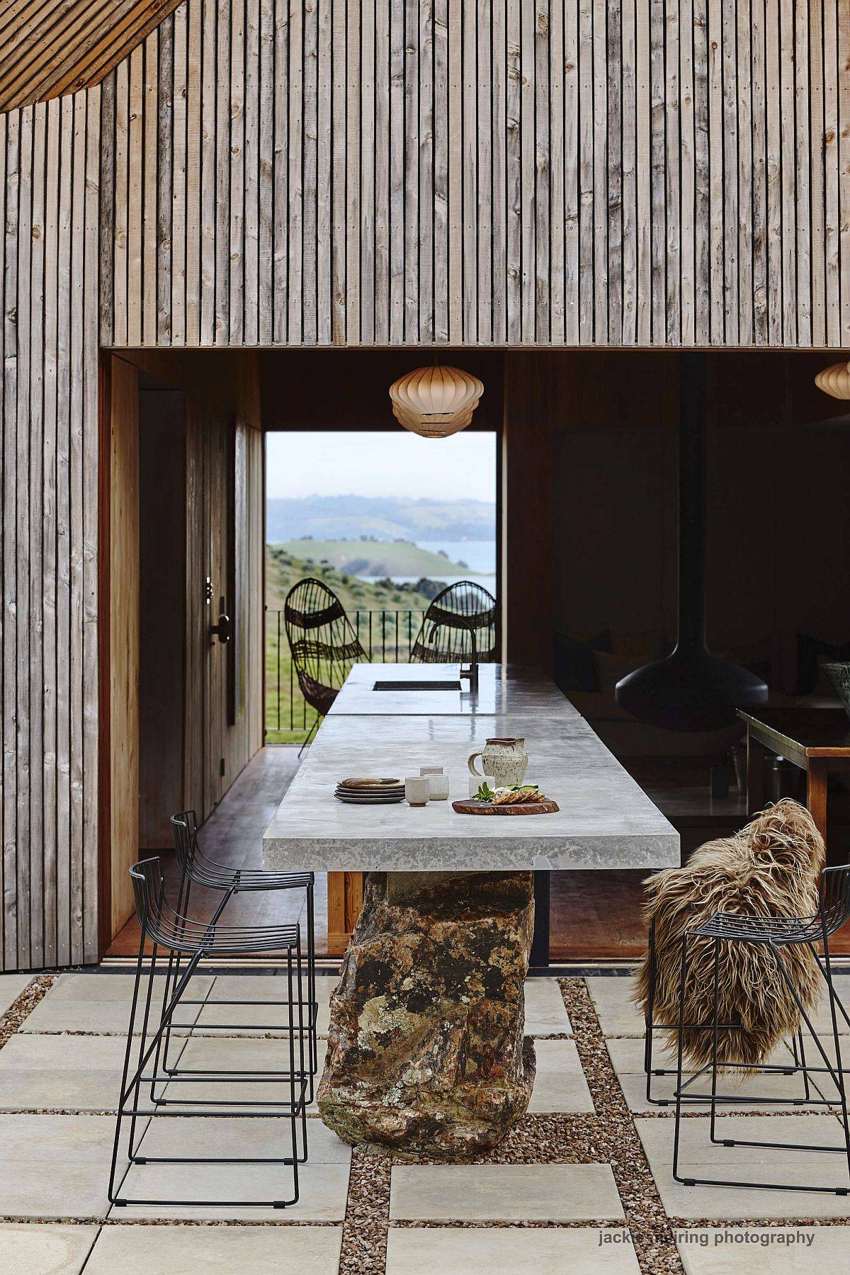 Kitchen inside the house extends into the outdoor sitting and eating area