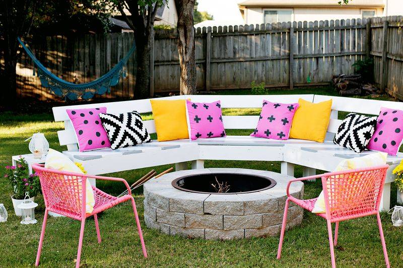 Pink and yellow cushions on long outdoor bench