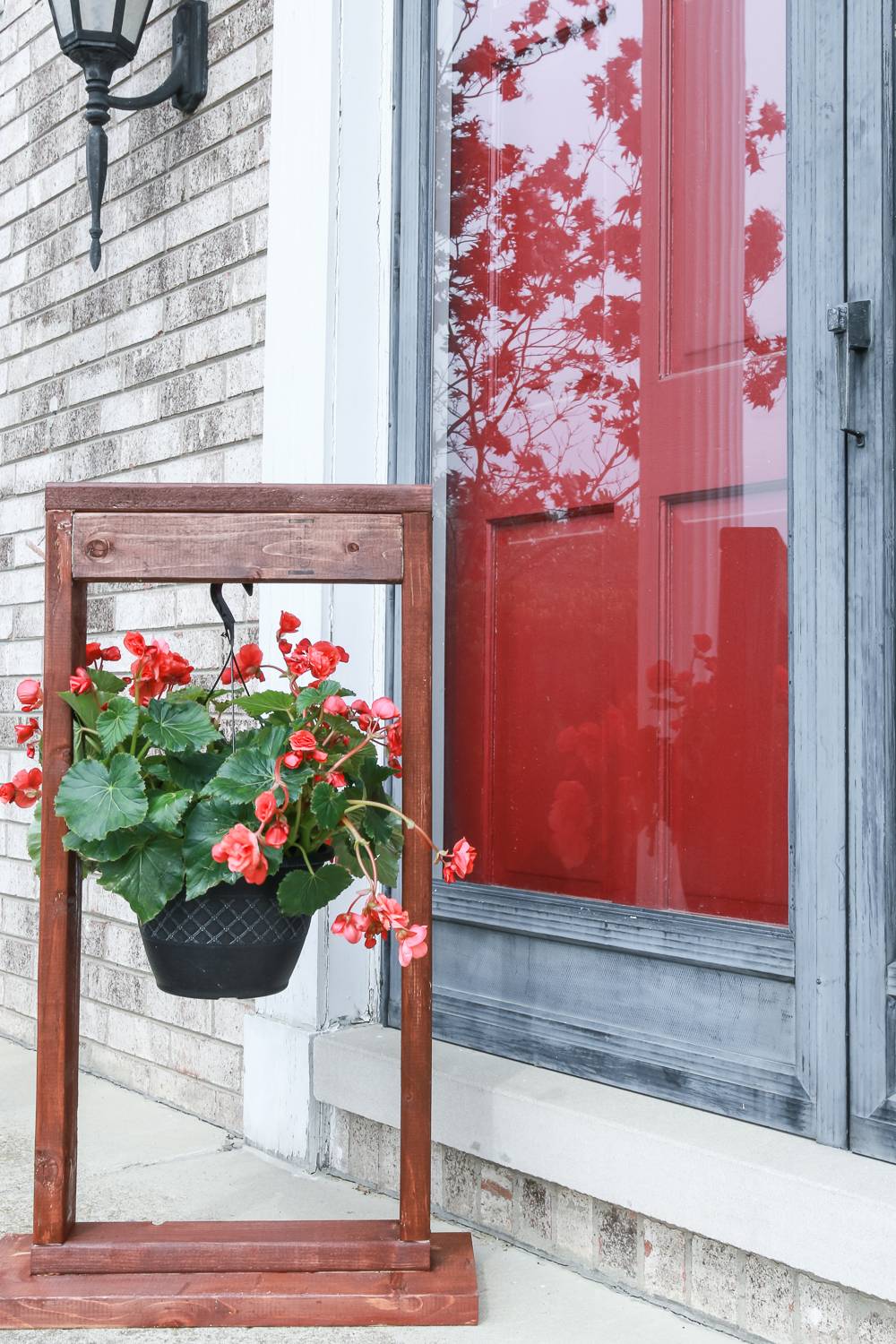 Red flowers hanging on a wood stand