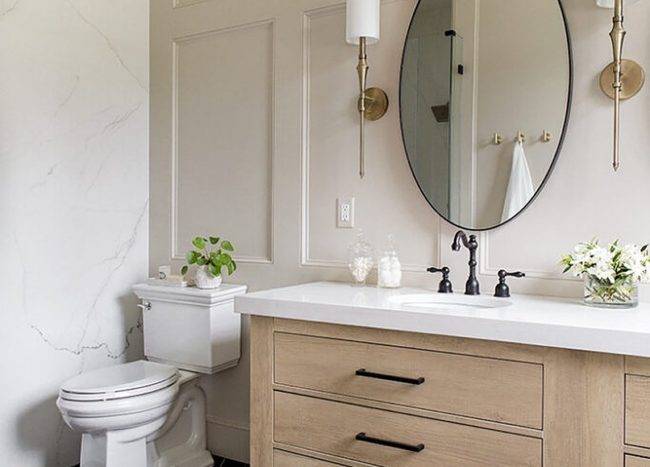 Round bathroom mirror in the middle of wall lamps