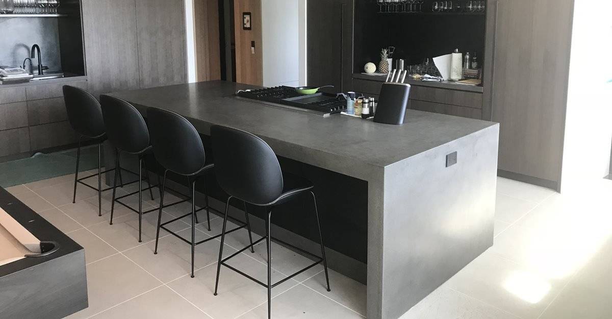 Sleek black kitchen counter with black accent chairs
