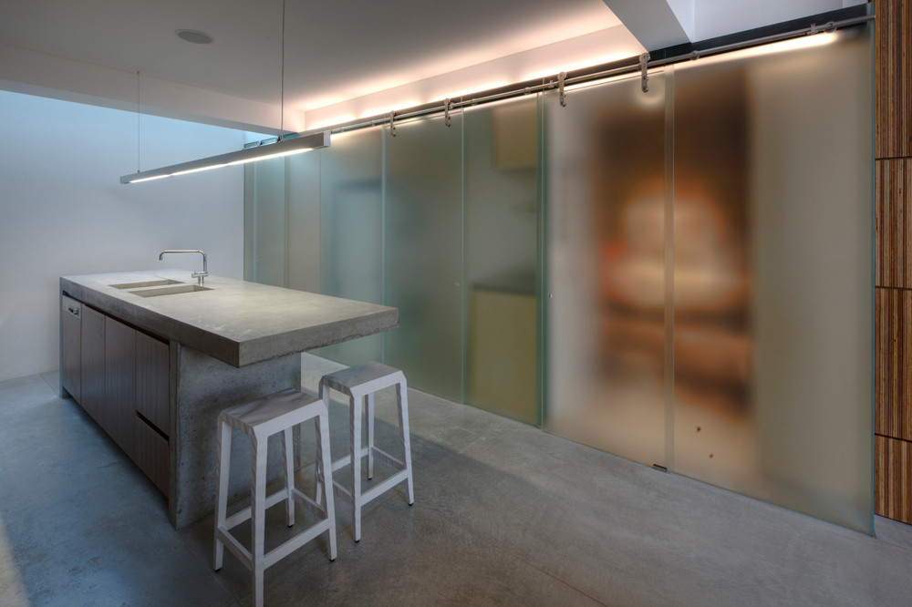 Sliding polycarbonate doors for the kitchen shelves and pantry make an instant impact