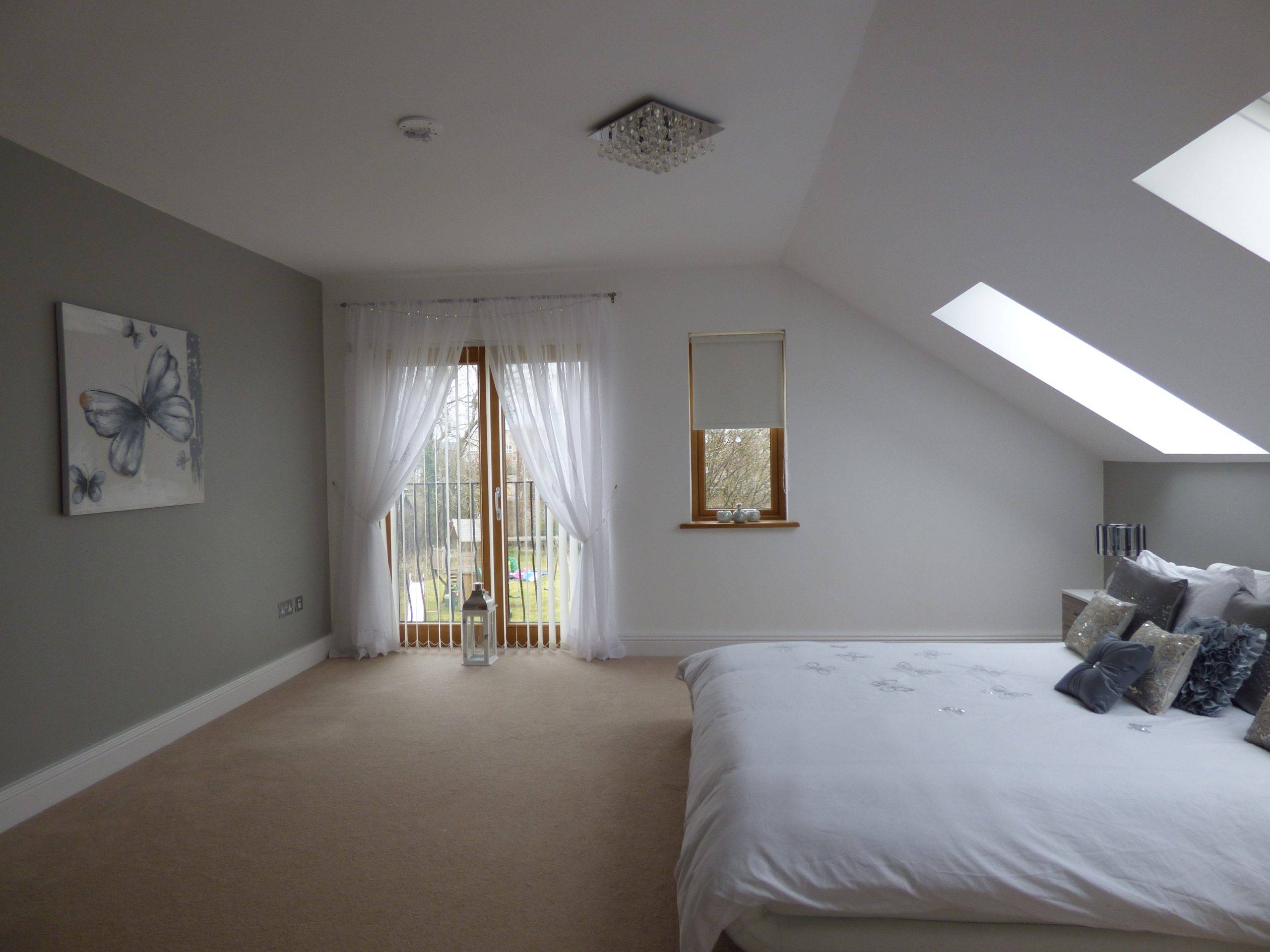 Spacious grey bedroom with large bed