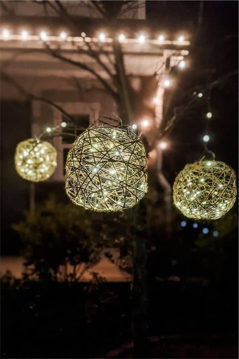 Three balled outdoor lights hanging from tree