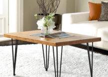 White flowers and open magazine on wood center table with thin metal legs