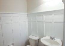 White toilet and white sink with white wall wainscoting