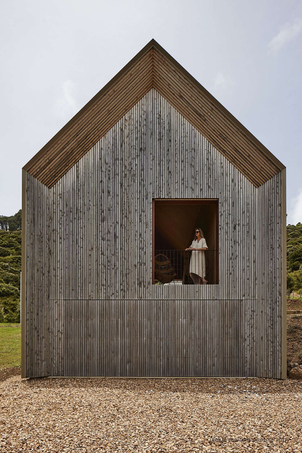 Woodsy exterior of the house with a chapel-like design and large windows