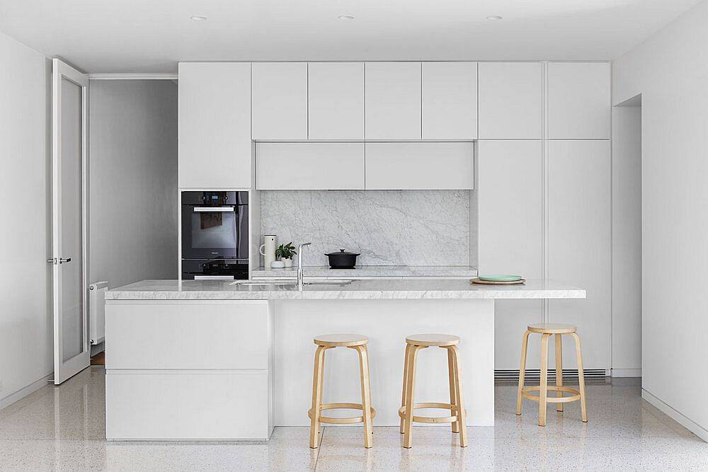 All-white modern kitchen design idea with stone countertops and polished shelves