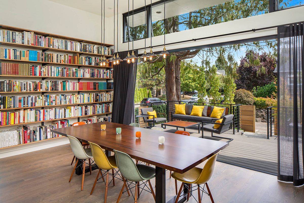 Bookshelves in the corner along with a deck and sitting area turn this dining space into a fun family and reading room