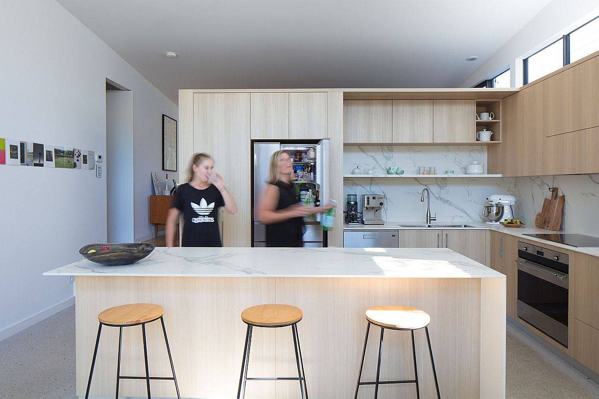 Contemporary kitchen in white and wood with marble countertops and backsplashes