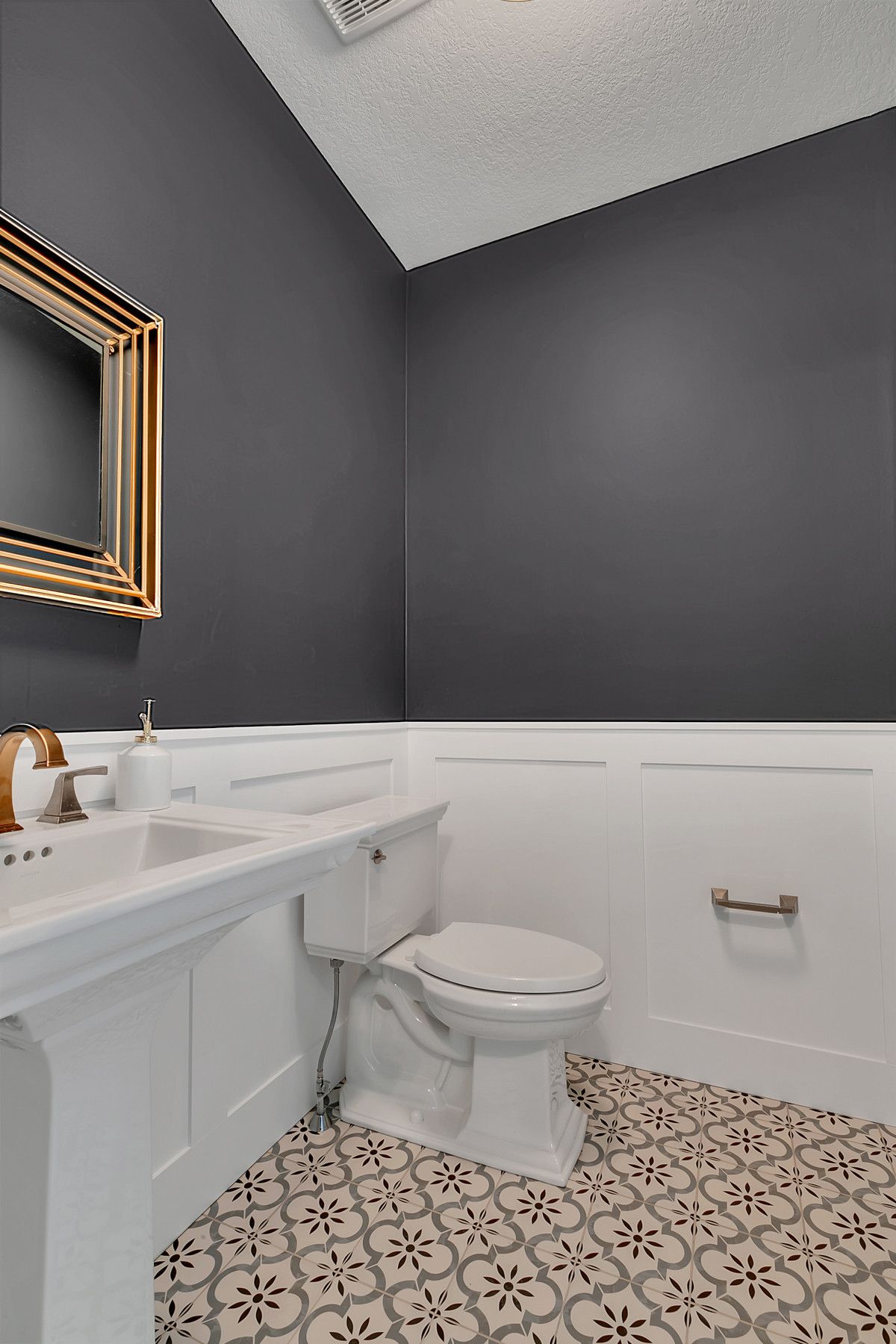 Dark gray and white bathroom with patterned tiles that usher in more visual contrast