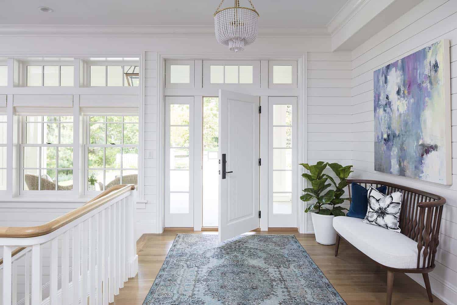 Entryway with large painting on the wall and blue rug