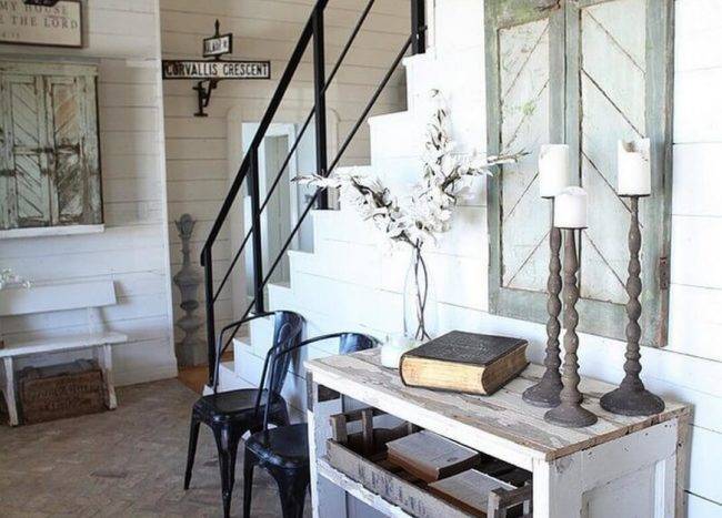 Entryway with wooden console and vintage window shutters on the wall