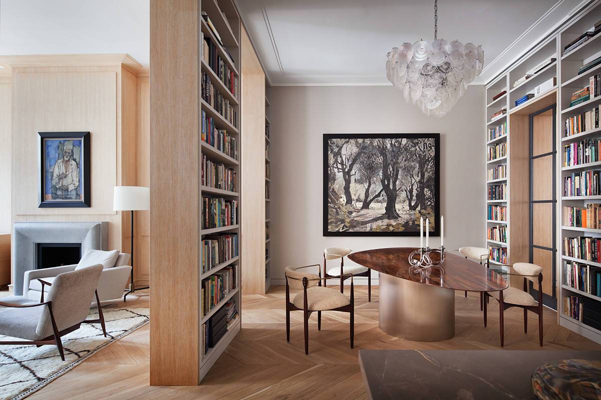 Floor-to-ceiling bookshelves create a unique identity for this dining area despite it being a part of the living room