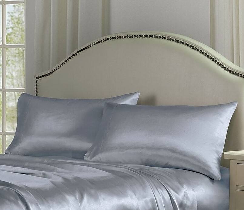 Grey satin sheet on bed with two pillows