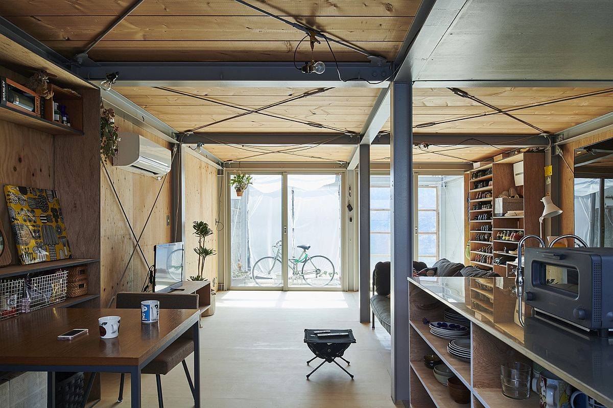 Kitchen and living area of the home with a steel frame and wooden walls and floors