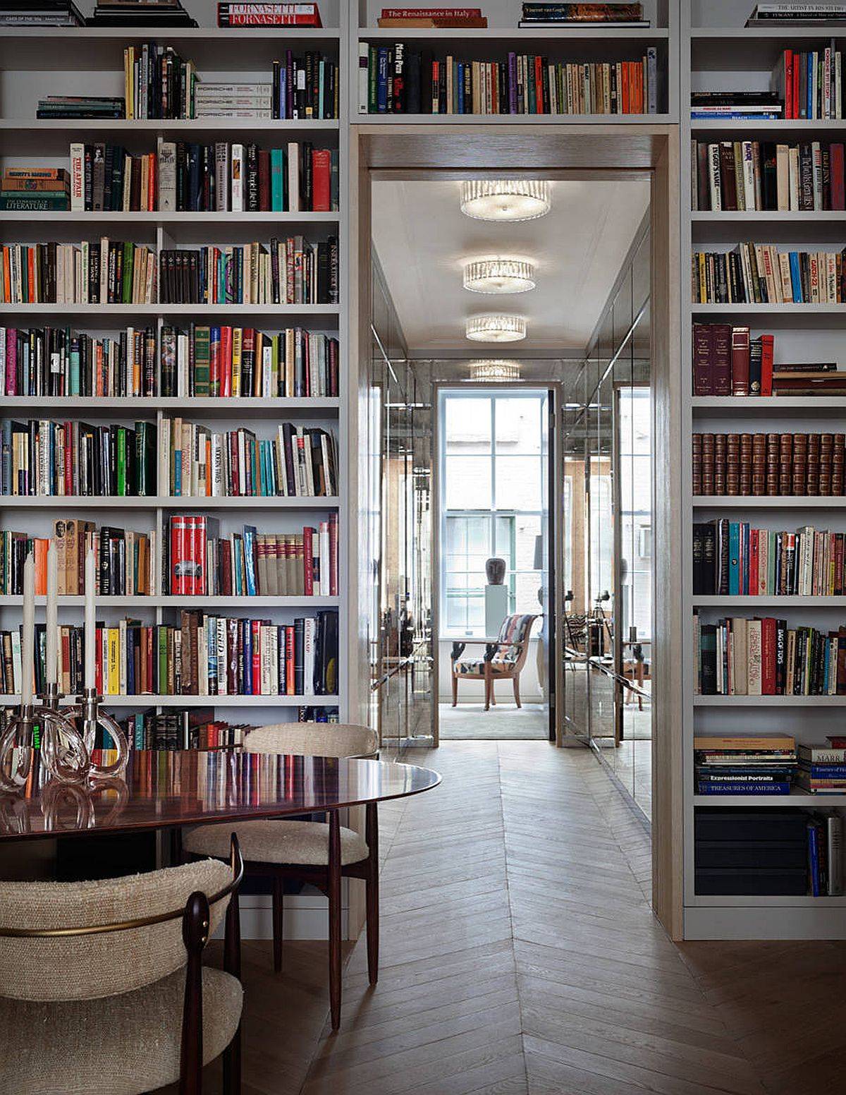 Lighting mirrors and the floor-to-ceiling bookshelves create a dramatic New York home