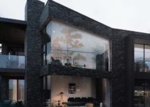 Living room visible through glass wall of a black house