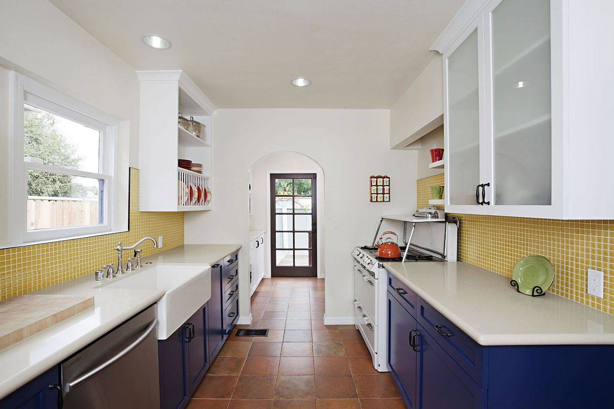 Modern white kitchen with yellow tiled backsplash and bright blue cabinets