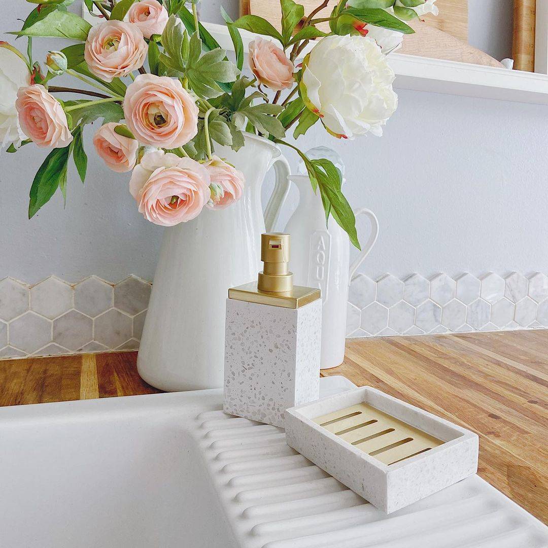 Pink roses on white vase beside sink