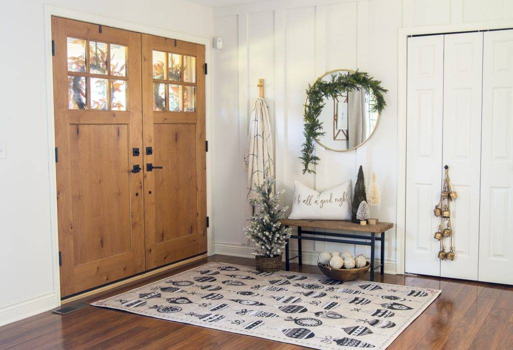 Round mirror with garland in entryway