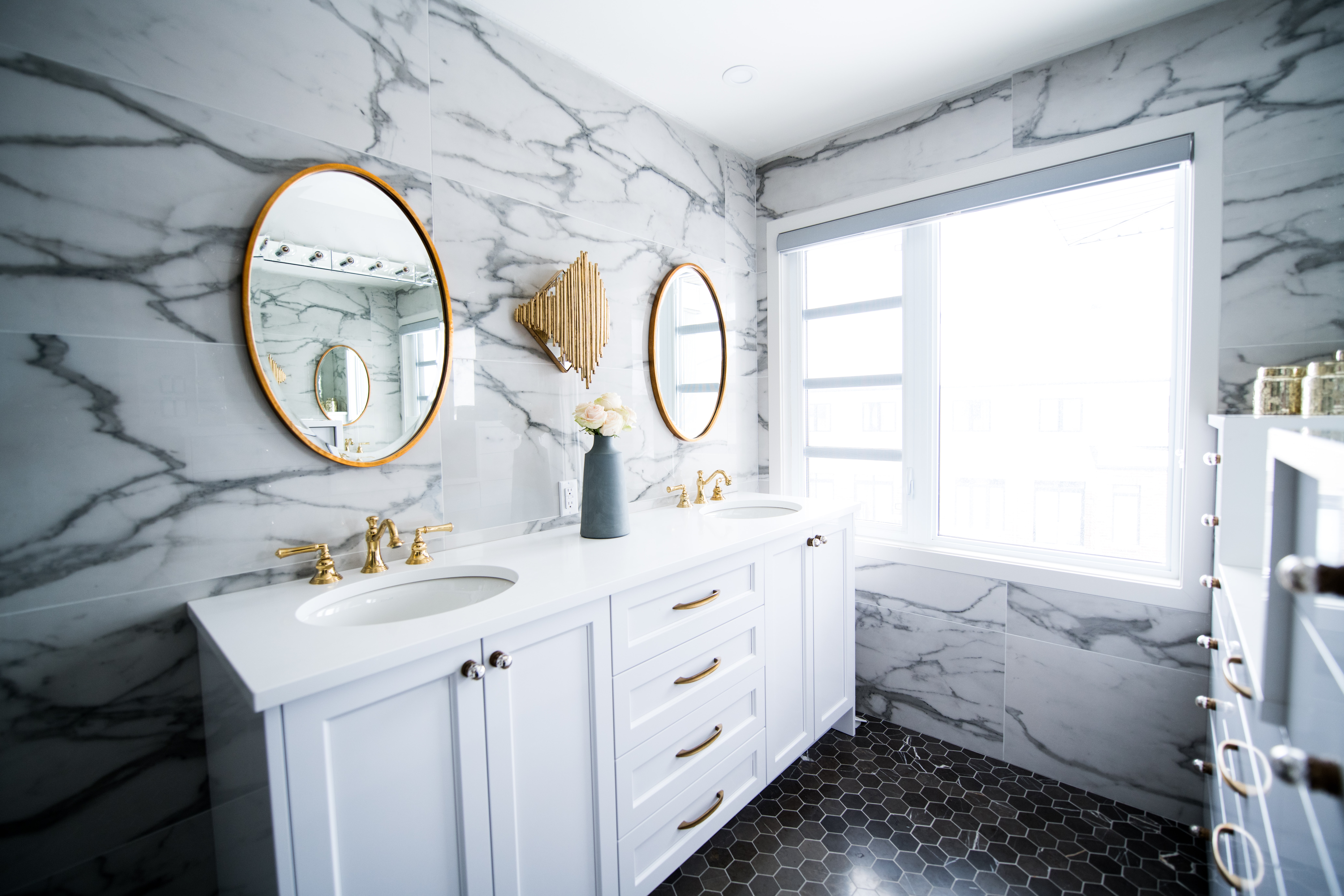 Two large mirrors and white double vanity inside bathroom