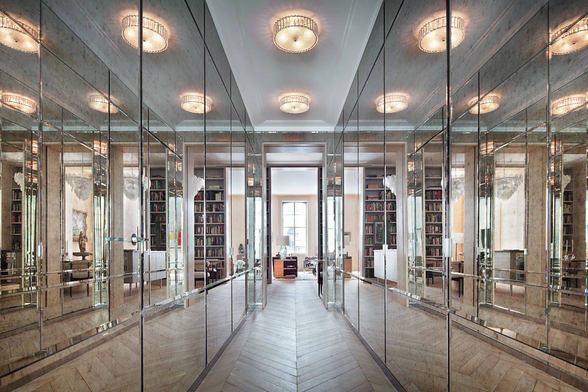 Visually stunning hallway with closets that feature antique mirrored doors