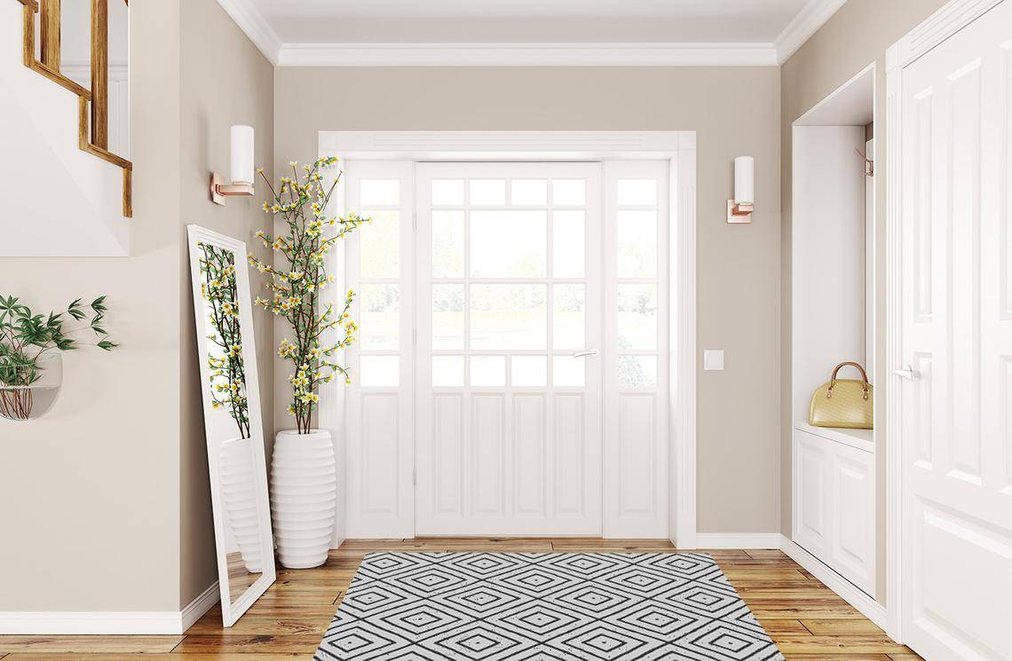 White entryway with yellow flowers on white pot