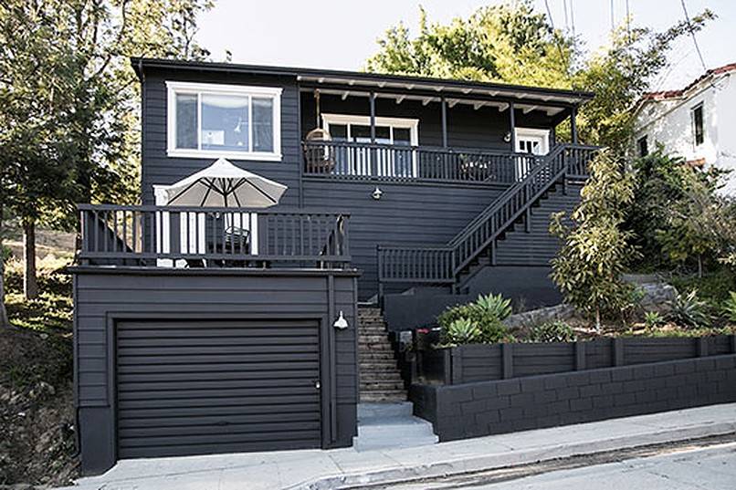 White patio umbrella on the deck of a black house