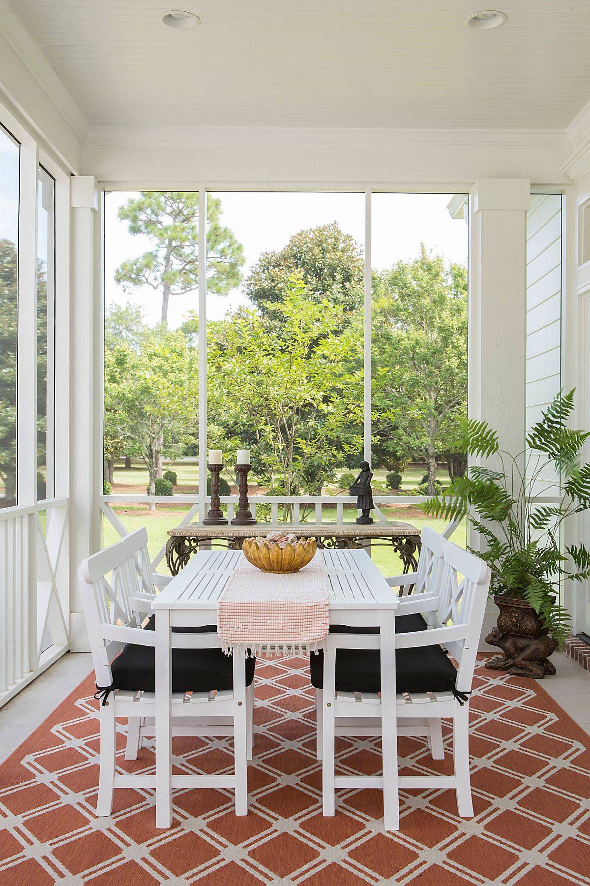 White shabby-chic porch with white decor and a rug that ushers in pops of terracotta