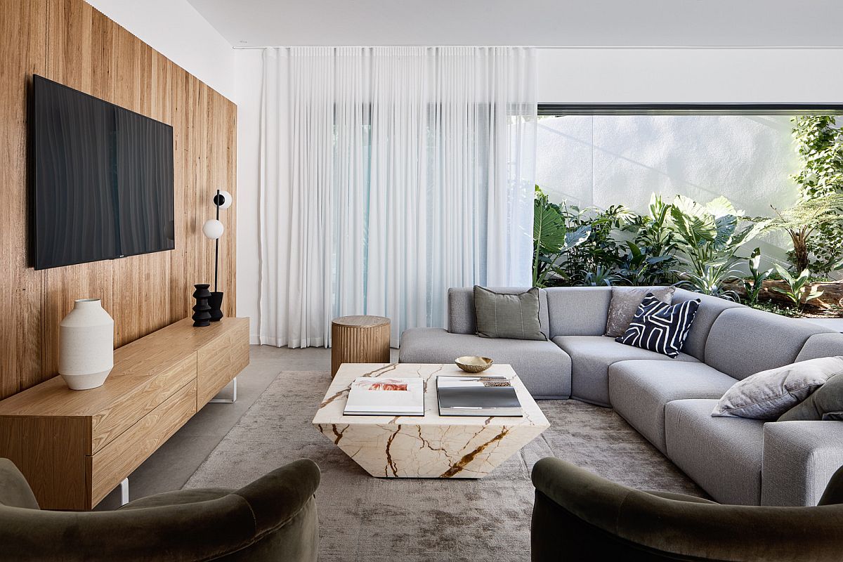 Wooden accent wall, entertainment unit, marble coffee table and greenery for the modern family room