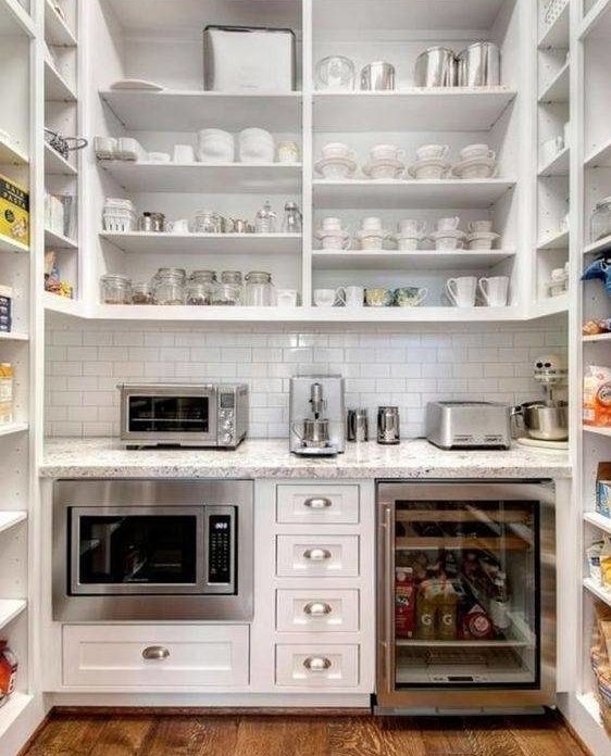 walk in pantry with organized shelves, microwave, wine fridge, and appliances