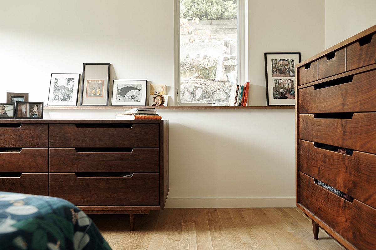 Bedroom in white with classic wooden drawers and ample natural light