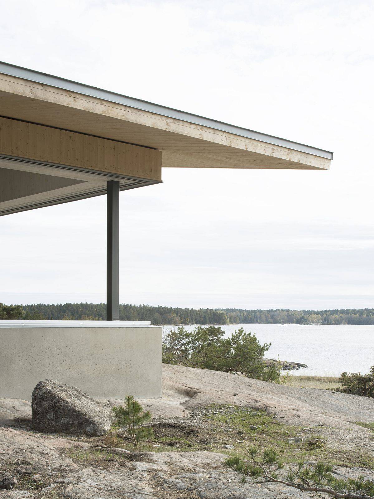 Concrete plinth around teh house creates a natural border with roof extending above it