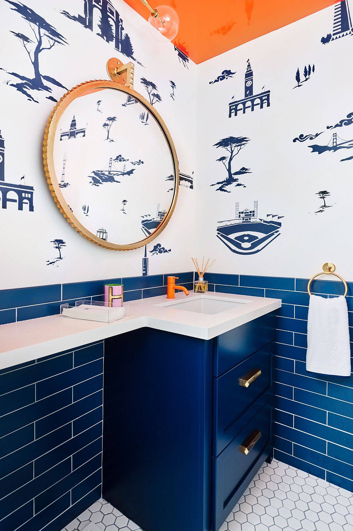 Custom blue cabinet, tiles and a wallpaper with midcentury vibe grace this eclectic powder room