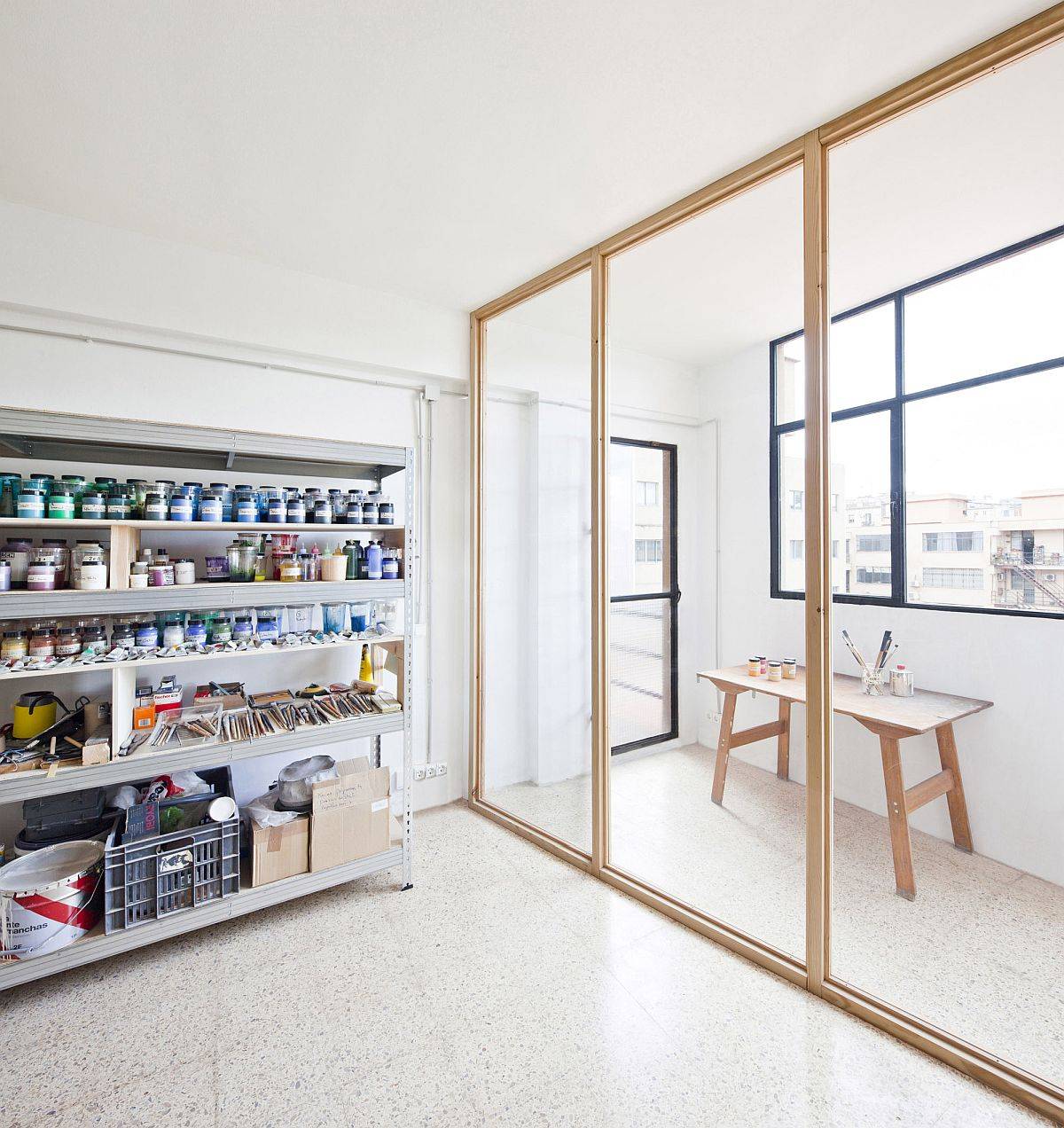 Glass doors with wooden frame create a room-within-a-room inside this Barcelona Studio