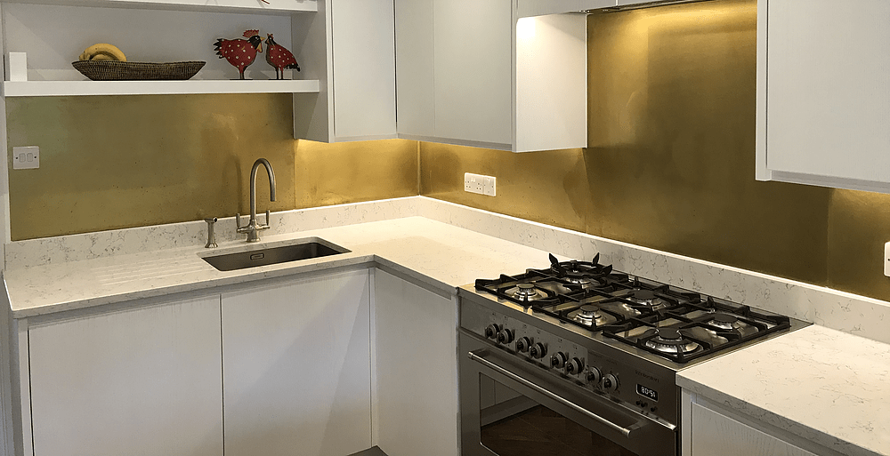 Modern Kitchen with White Cabinet and Brass Backsplash