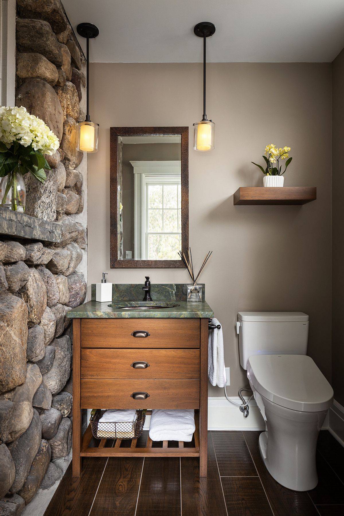 Rustic powder room inspired by the classic cabin-style in New York with a stone wall