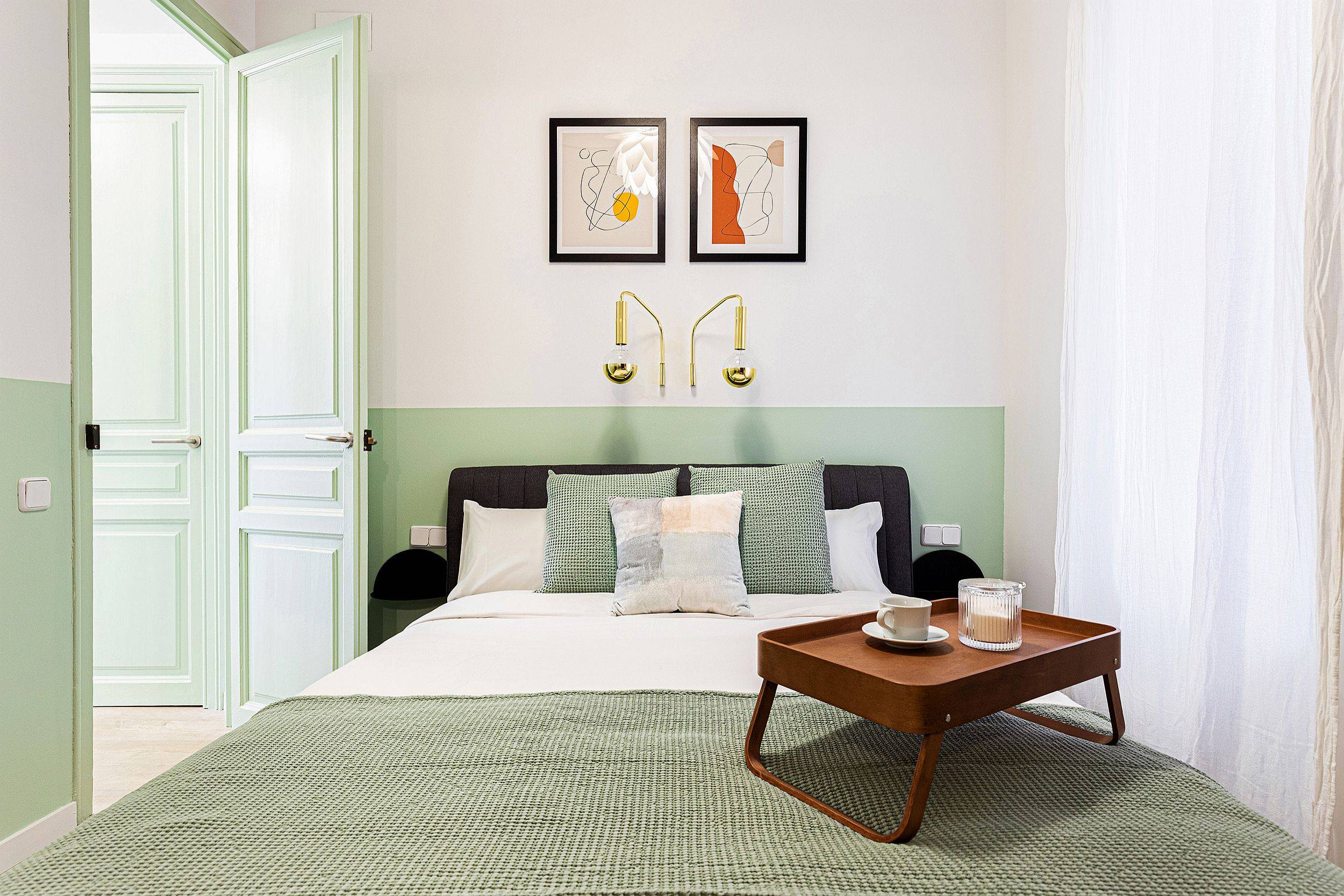 Small and stylish modern bedroom in white and pastel green is perfect for the vacation apartment