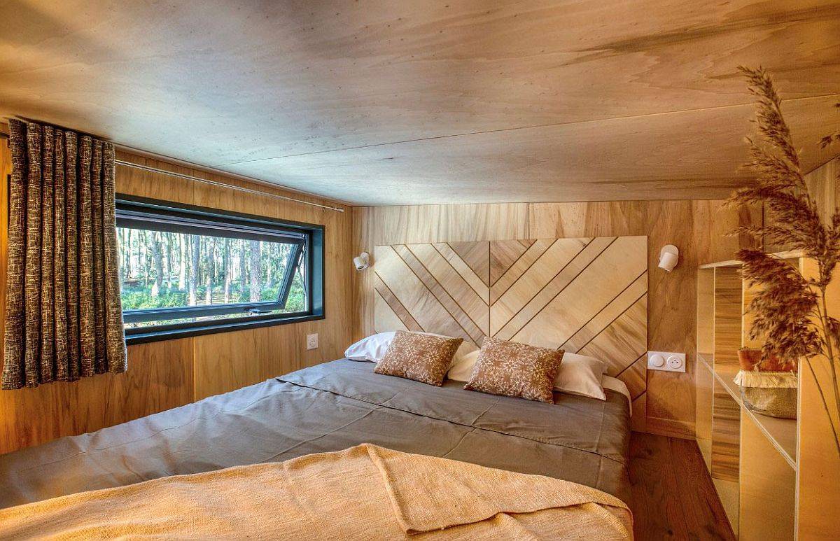 Tiny loft bedroom of the home with chevron pattern headboard that ushers in pattern