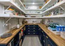 walk in pantry with navy cabinets and butcher block counter