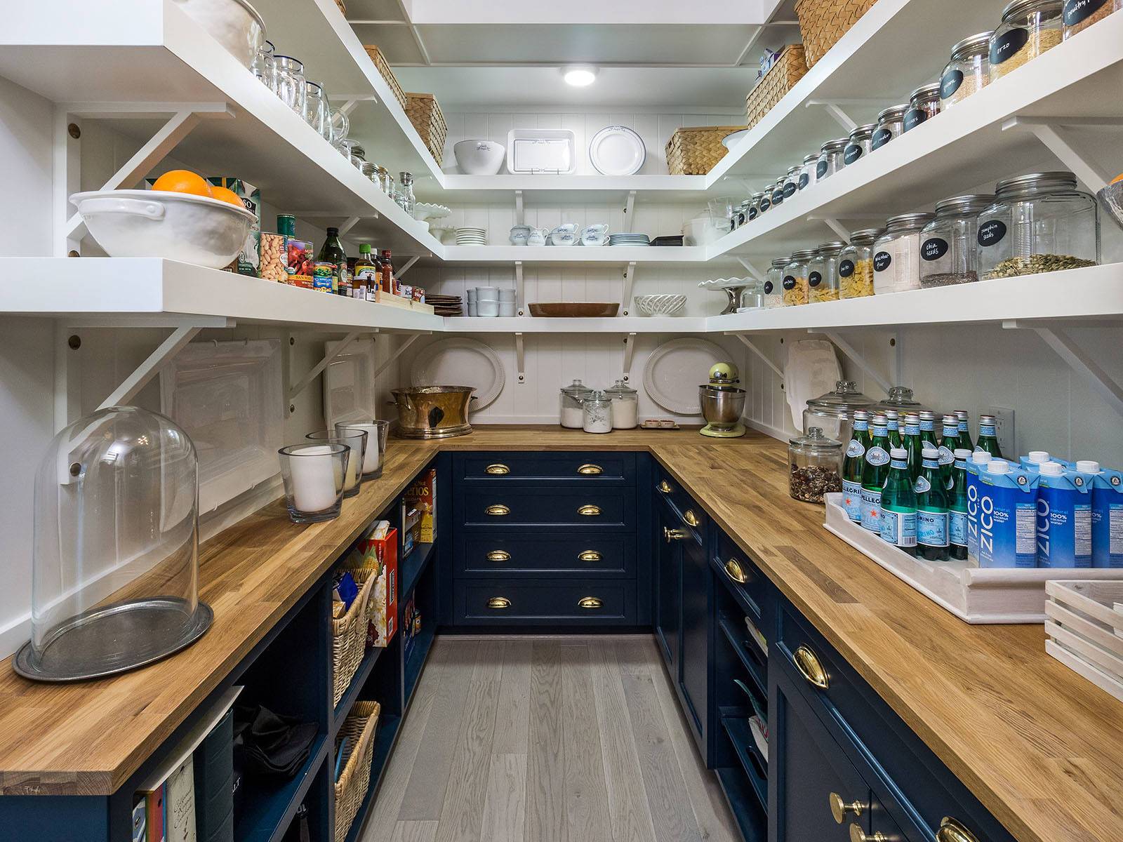 walk in pantry with navy cabinets and butcher block counter