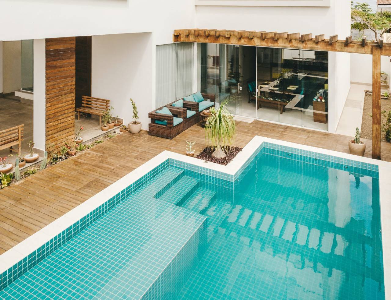 patio furniture on deck next to turquoise pool