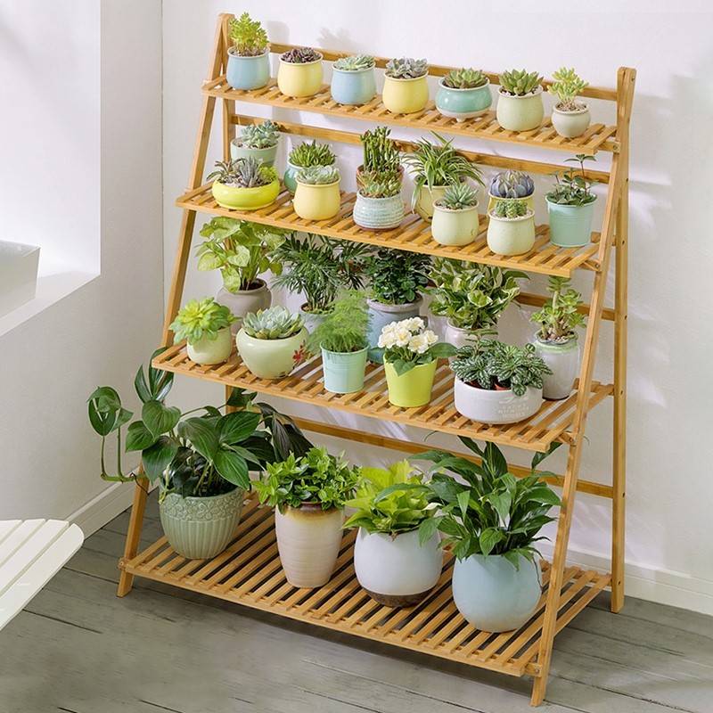 bamboo hanging plant stand with rows of succulents and plants 