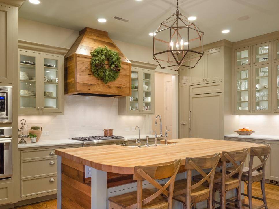 light wood kitchen island with curved chairs against beige cabinets 