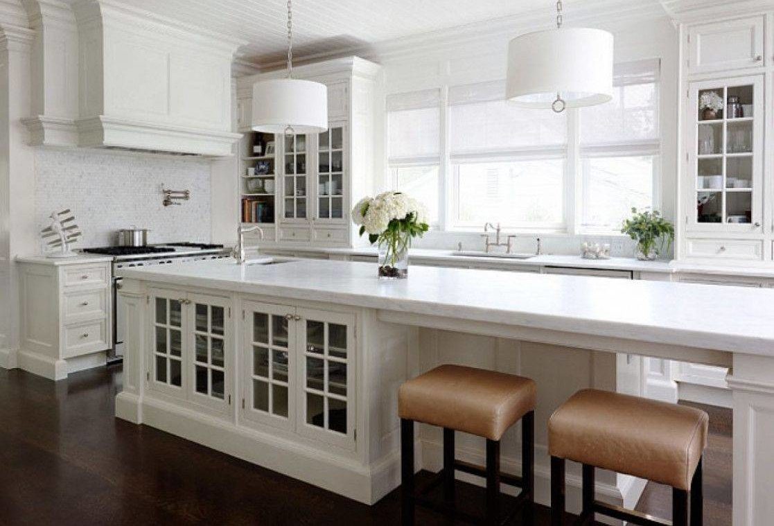 long white kitchen island with built in cabinets and low stools
