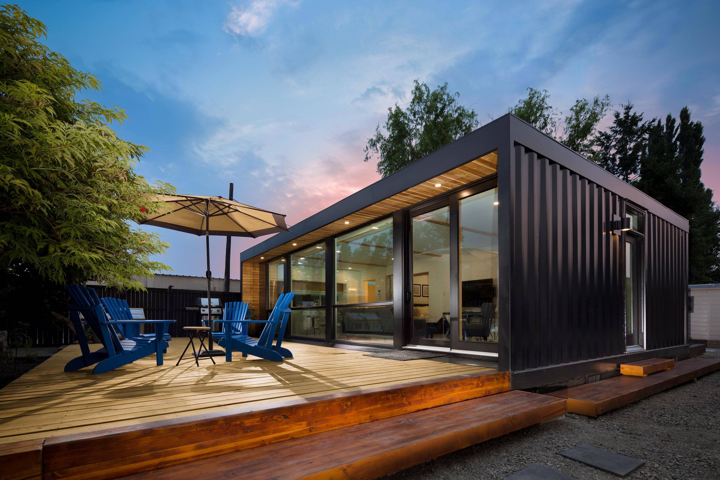 black steel container home with wooden patio